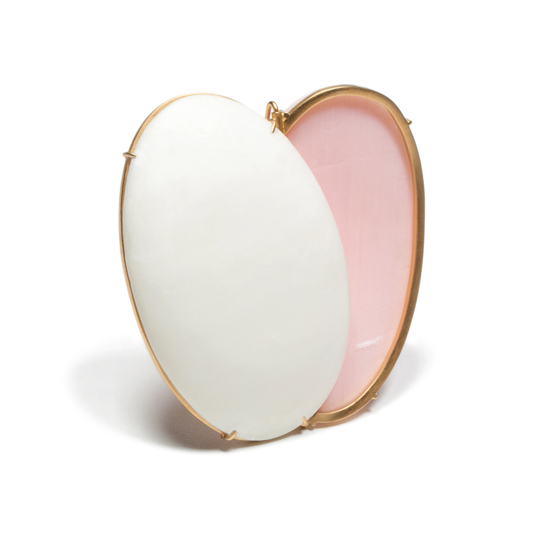 A white, pink, and gold brooch.