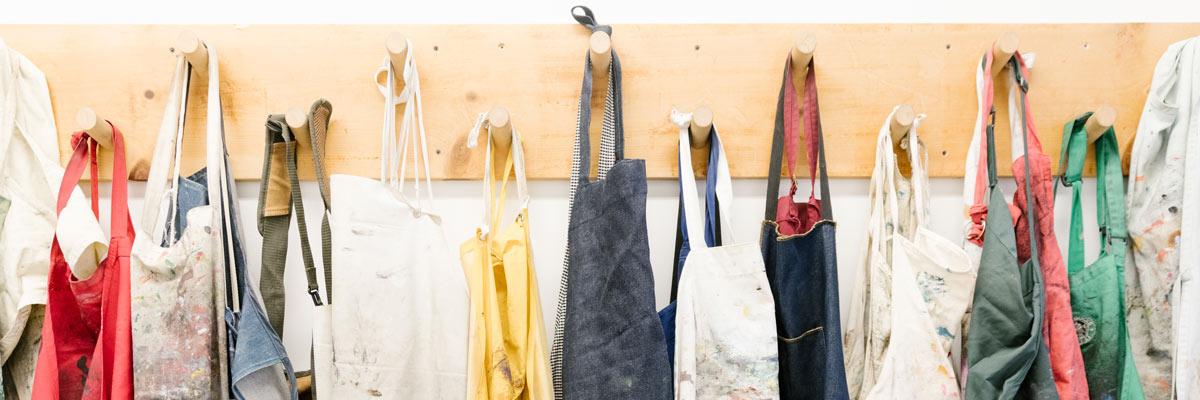 Art aprons hanging on a wall.