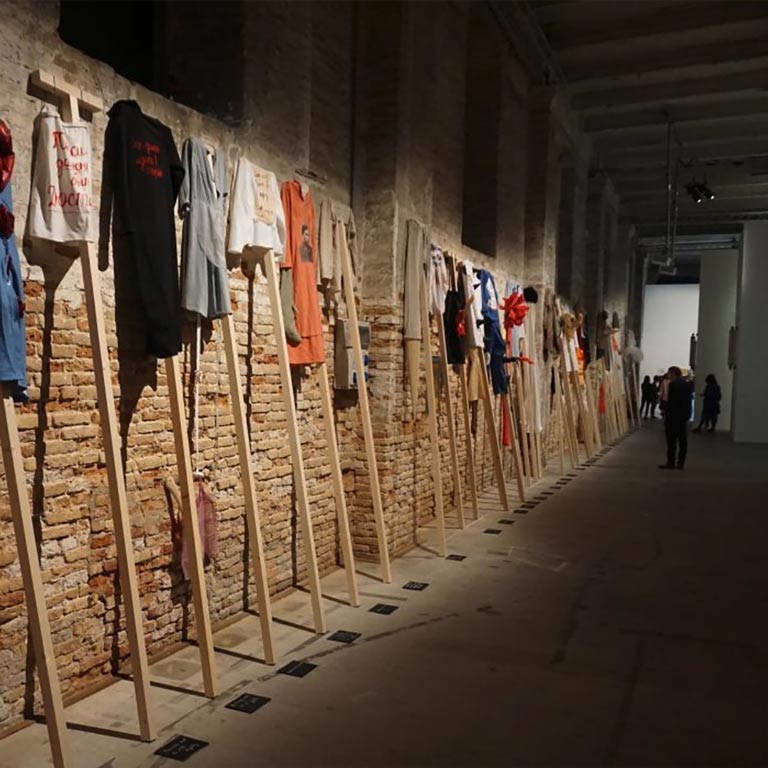 Clothing hung up high in a brick gallery.