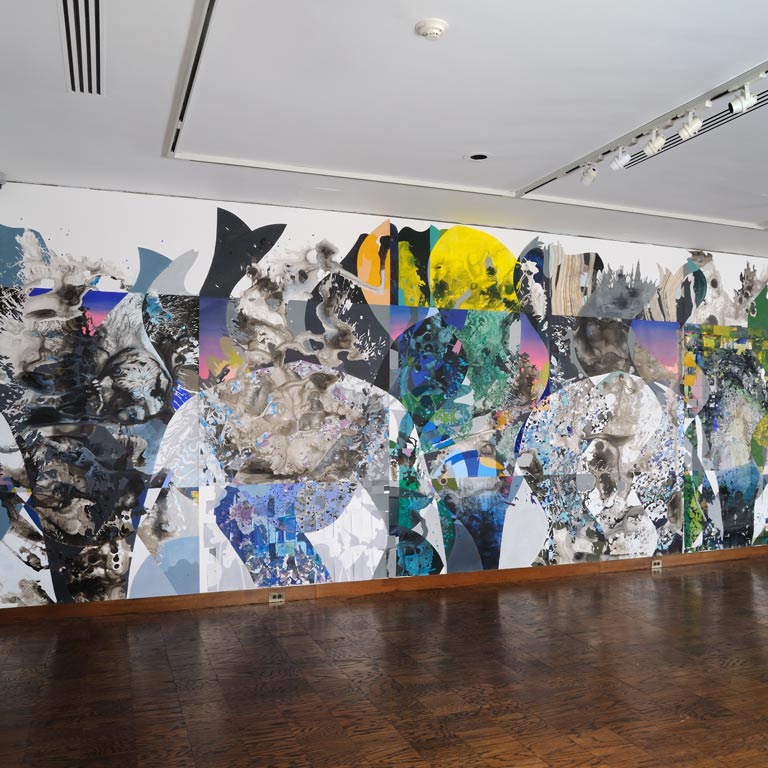 A large colorful artwork taking up multiple walls in a gallery.