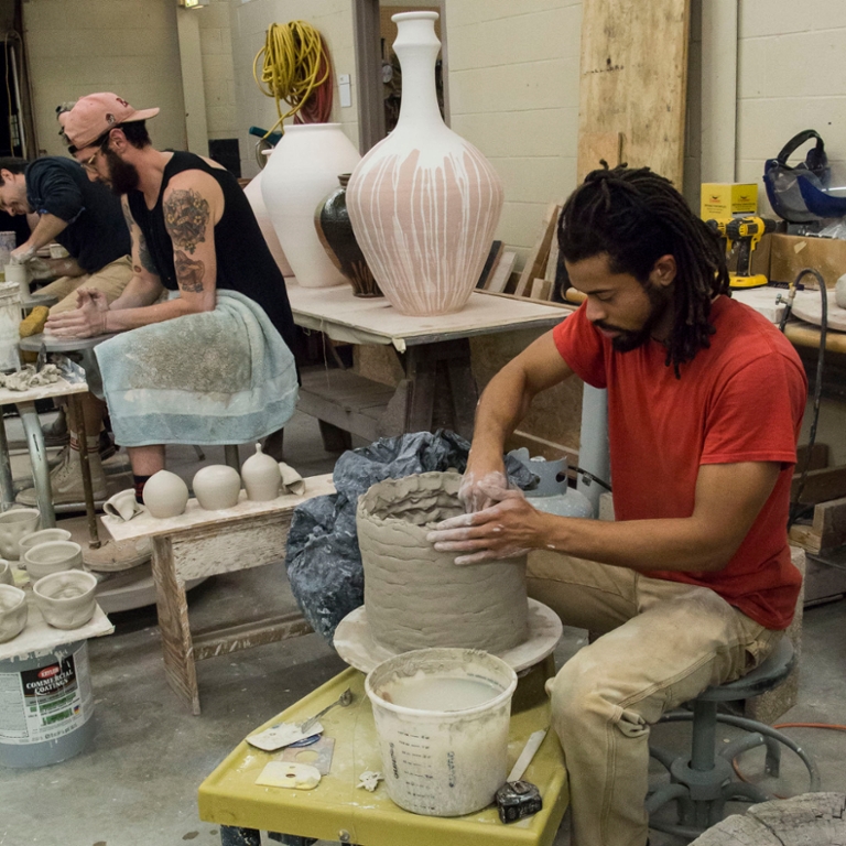 People work in a ceramics studio.