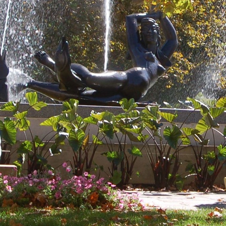 A fountain surrounded by greenery. 