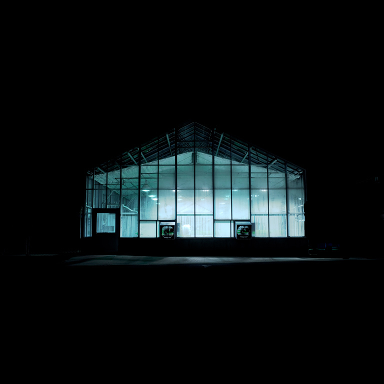 A photo of a greenhouse at night.