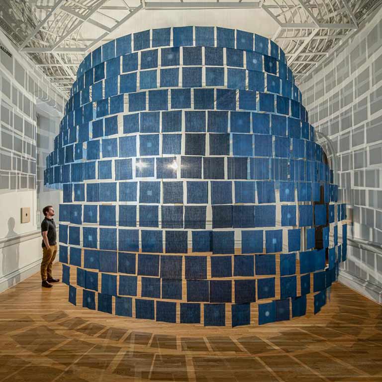 A large blue textile installation in a gallery.