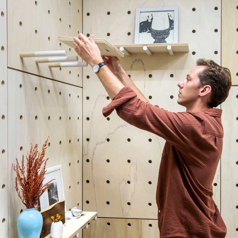A person installs a shelf.