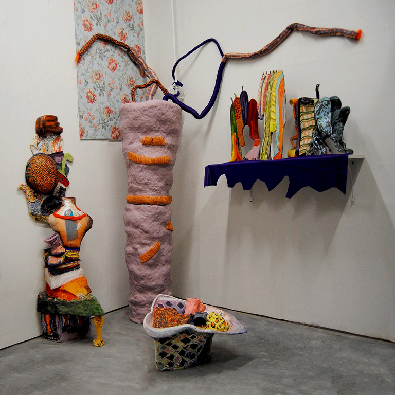 Colorful sculptures in the corner of a gallery.